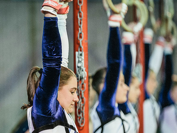 Junges Mädchen beim Turnen an den Ringen