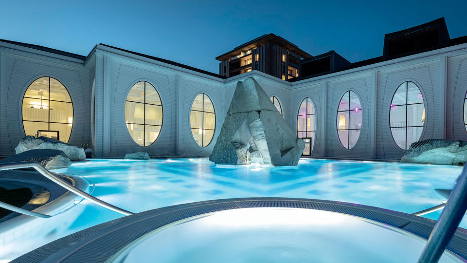 Aussenblick auf ein Becken und das Gebäude der Tamina Therme in Bad Ragaz